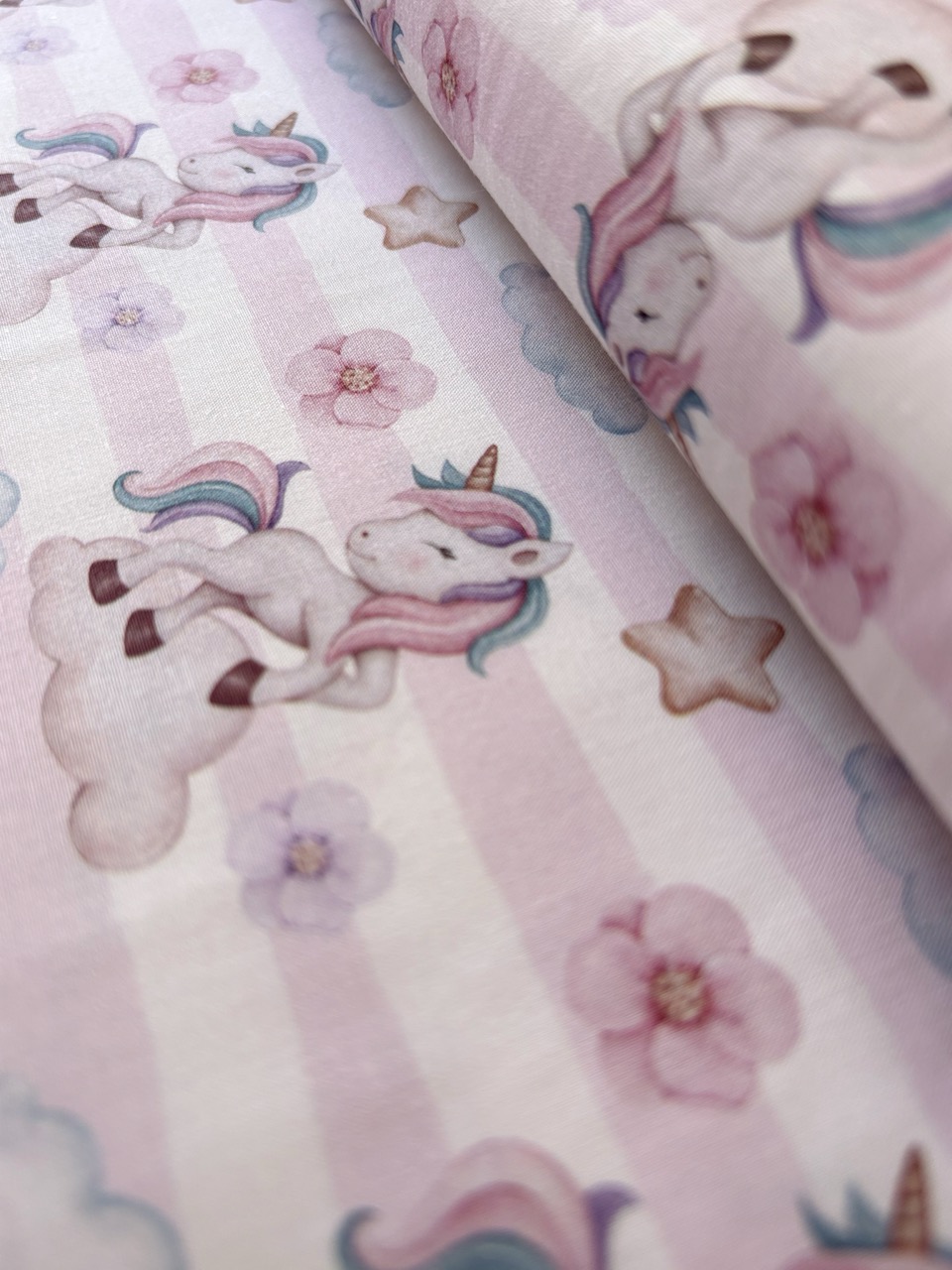 Algodón estampado · unicornios sobre rayas rosas